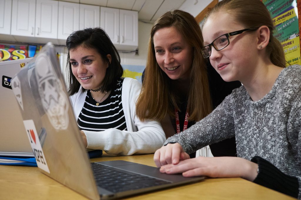 Middle School girls working with teacher - Manlius Pebble Hill School